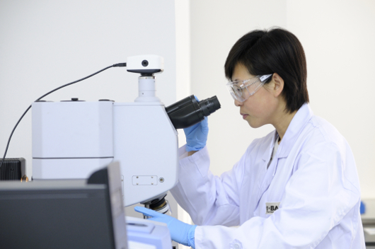 A women is working with a microscope in a lab in the technical Center in Shanghai. 
