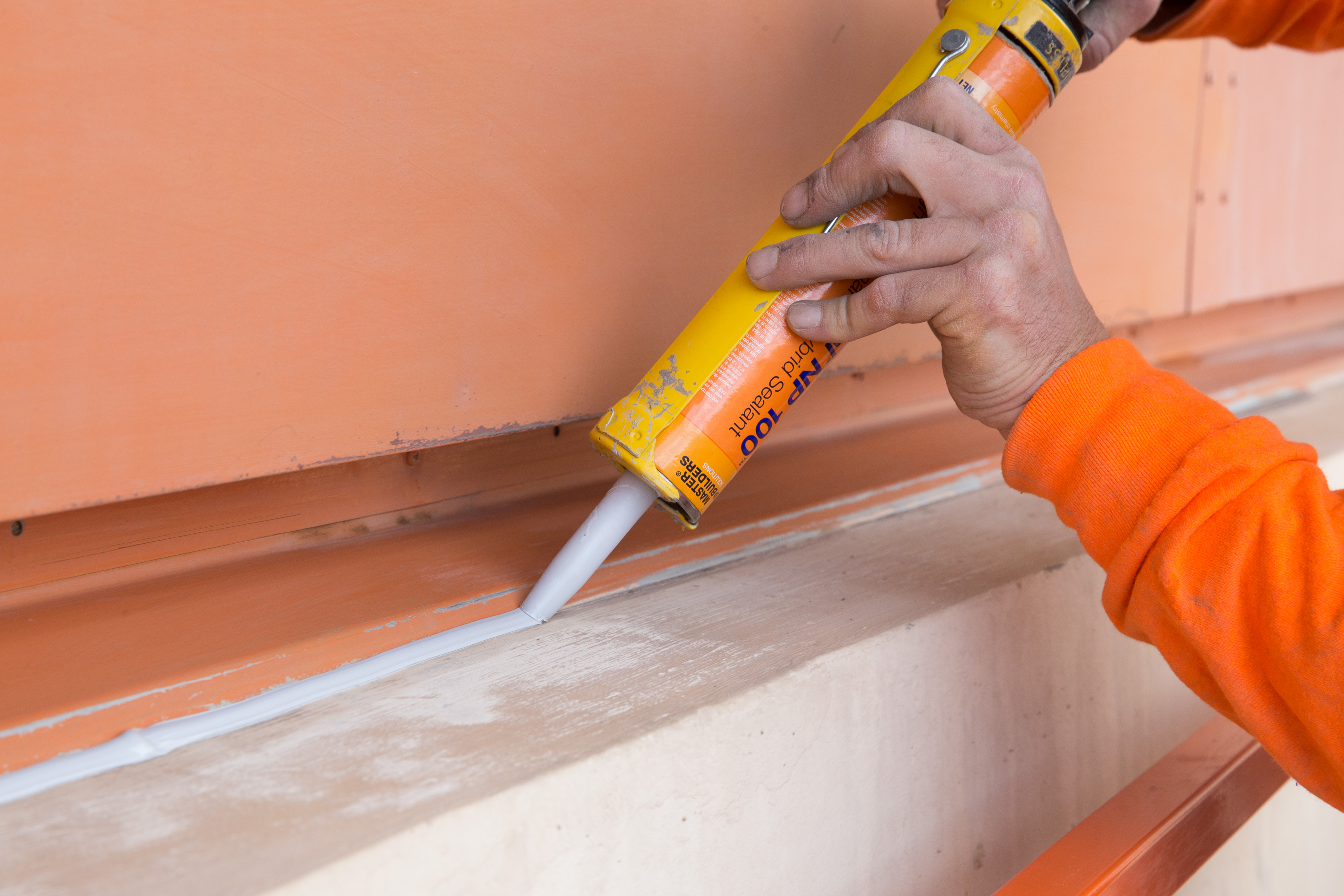 Construction sealant being used to fill an exterior joint.